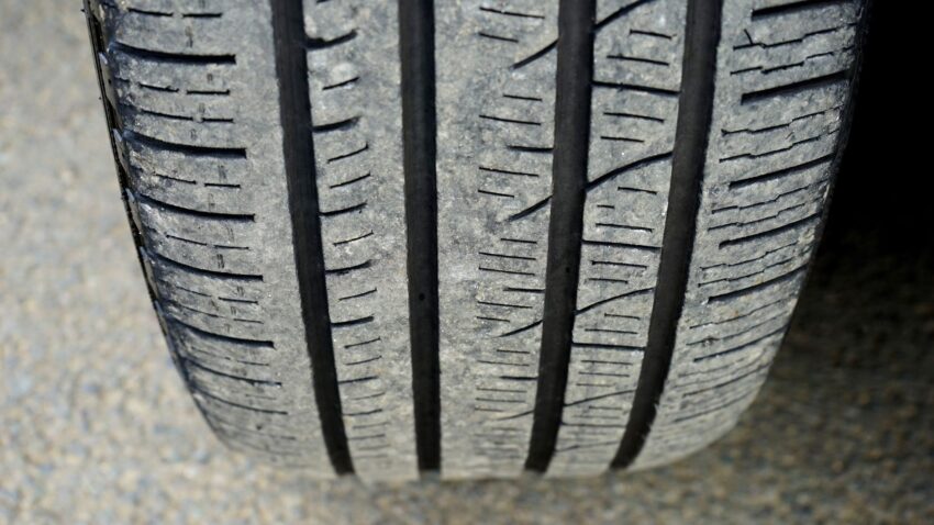 Close-up van een zichtbaar versleten autoband met groeven in het loopvlak